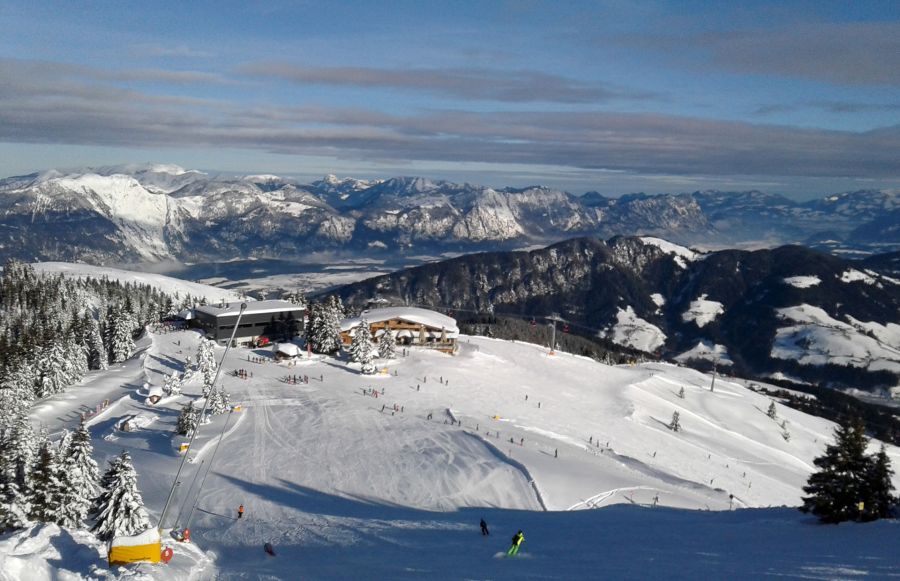 Skigebiet mit verschneiten Pisten und weitem Blick auf die Tiroler Berge