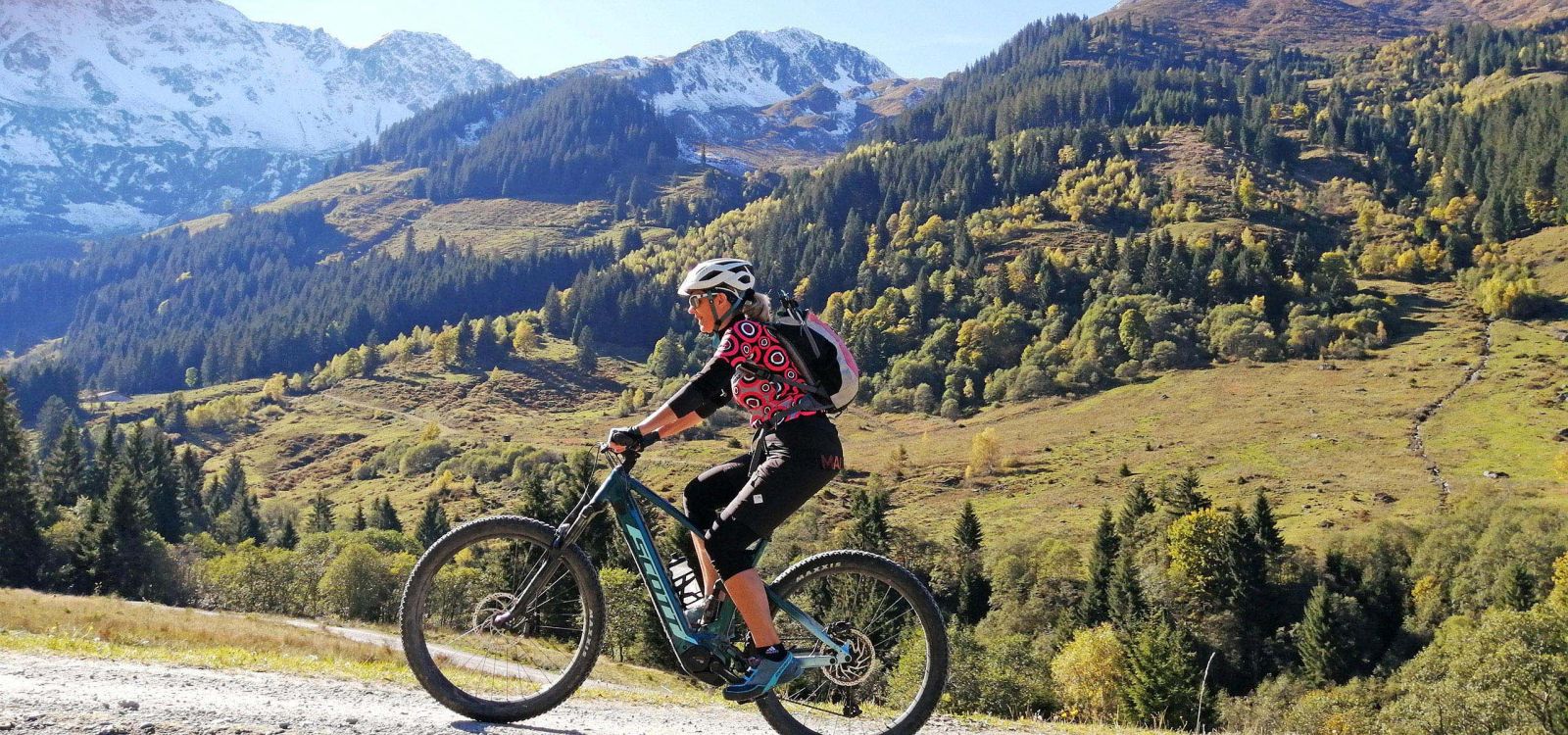 Mountainbikerin auf E-Bike vor alpiner Berglandschaft in der Wildschönau