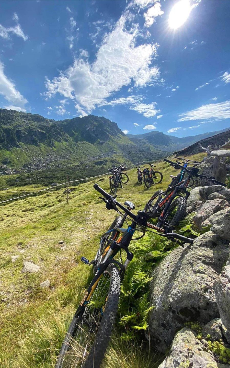 E-Bikes auf einer Almwiese mit felsiger Berglandschaft und blauem Himmel