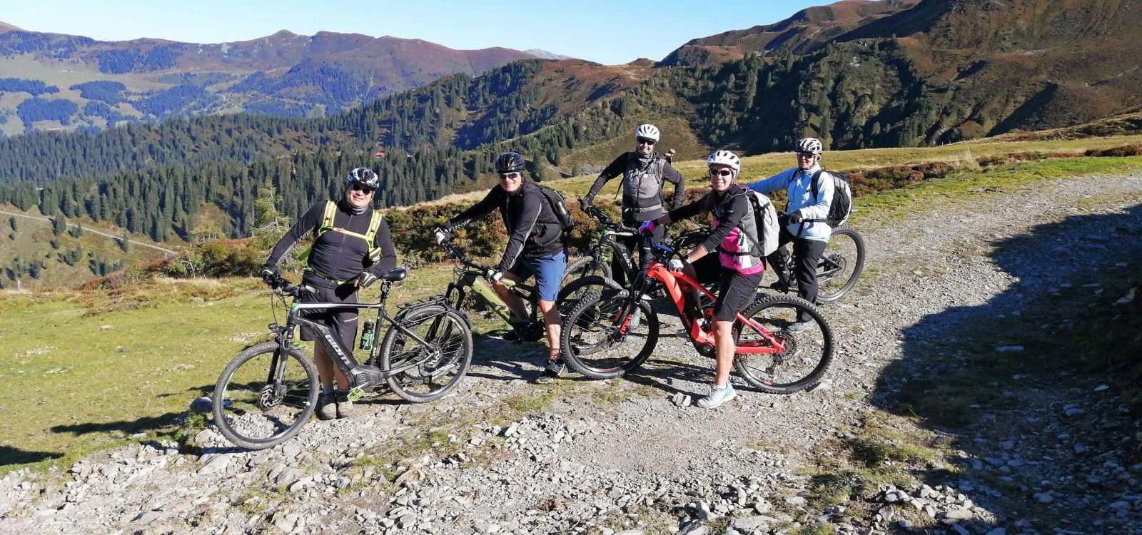 Mountainbike-Gruppe auf alpinem Schotterweg mit Panoramablick in der Wildschönau