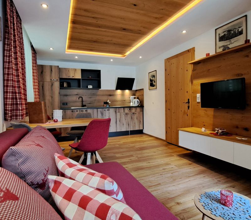 Wohnbereich im Appartement Feldalphorn mit Sofa, Essecke, Küche und TV