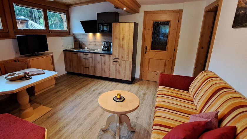 Wohnküche im Appartement Großer Beil mit Sofa, Esstisch, Küchenzeile und TV