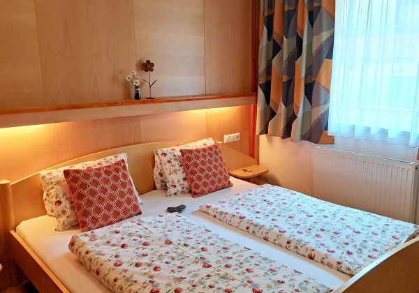 Gemütliches Schlafzimmer im Appartement Feldalphorn mit Doppelbett und warmem Holzambiente