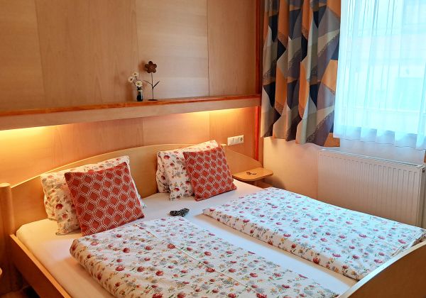 Gemütliches Schlafzimmer im Appartement Feldalphorn mit Doppelbett und warmem Holzambiente